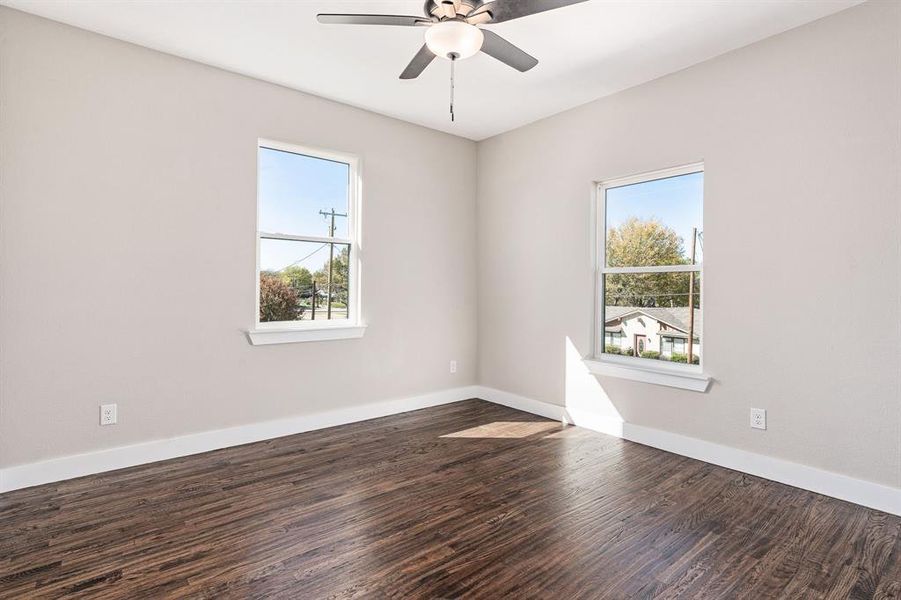 Spare room featuring ceiling fan and dark hardwood / wood-style floors