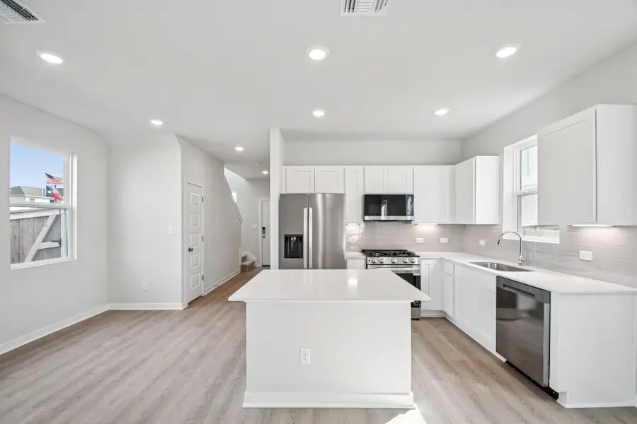 A kitchen with white cabinets.