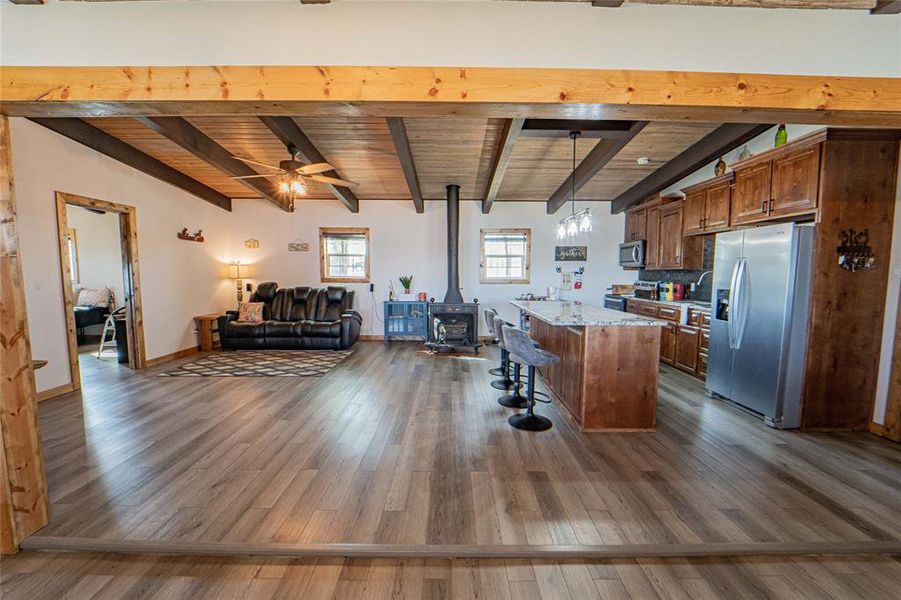 Open-concept living with exposed wood beams-Cozy wood-burning stove for year-round comfort Open-concept living with exposed wood beams-Cozy wood-burning stove for year-round comfort