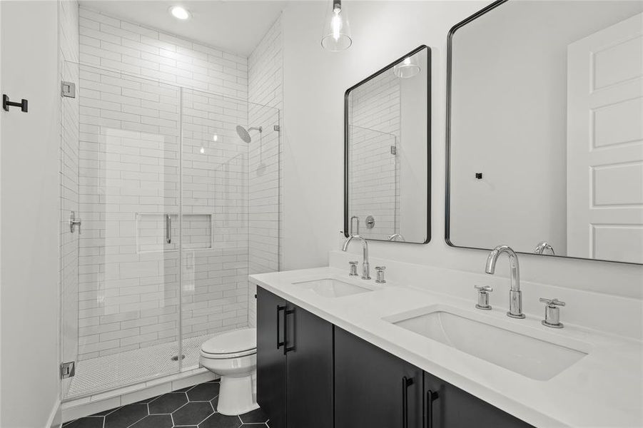 Full bath featuring a stall shower, dark tile patterned flooring, double vanity, and recessed lighting