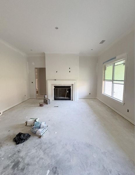 Recessed lighting, crown molding, fireplace with mantel, window with white trim