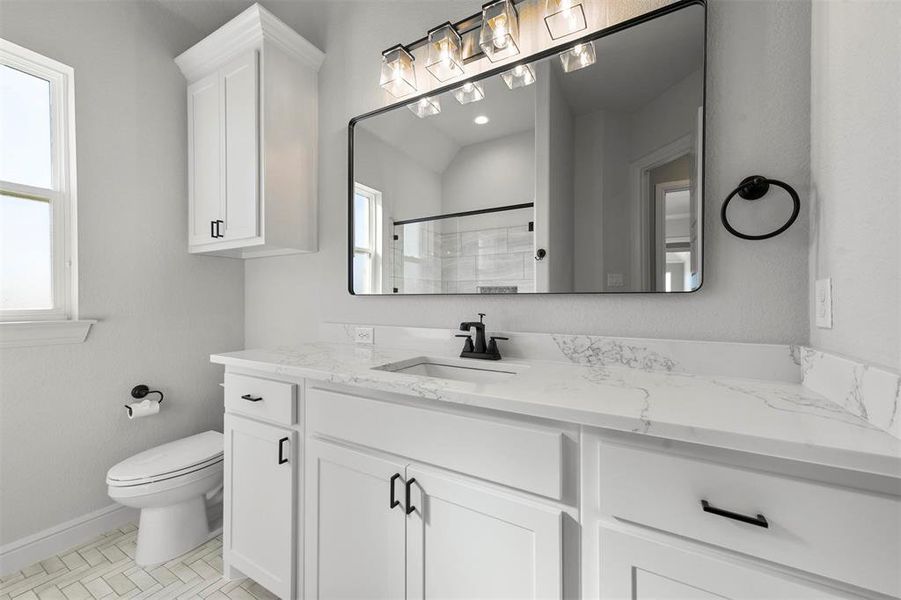 Bathroom featuring vanity, a healthy amount of sunlight, toilet, and walk in shower