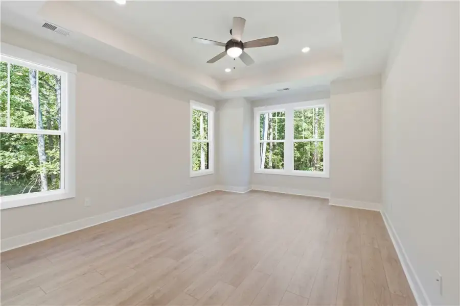 An elegant tray ceiling and rich wood floors frame
