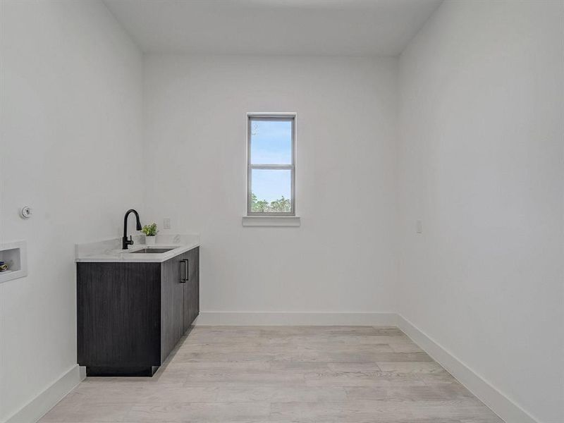 Laundry room with cabinet space, hookup for a washing machine, and light wood-type flooring