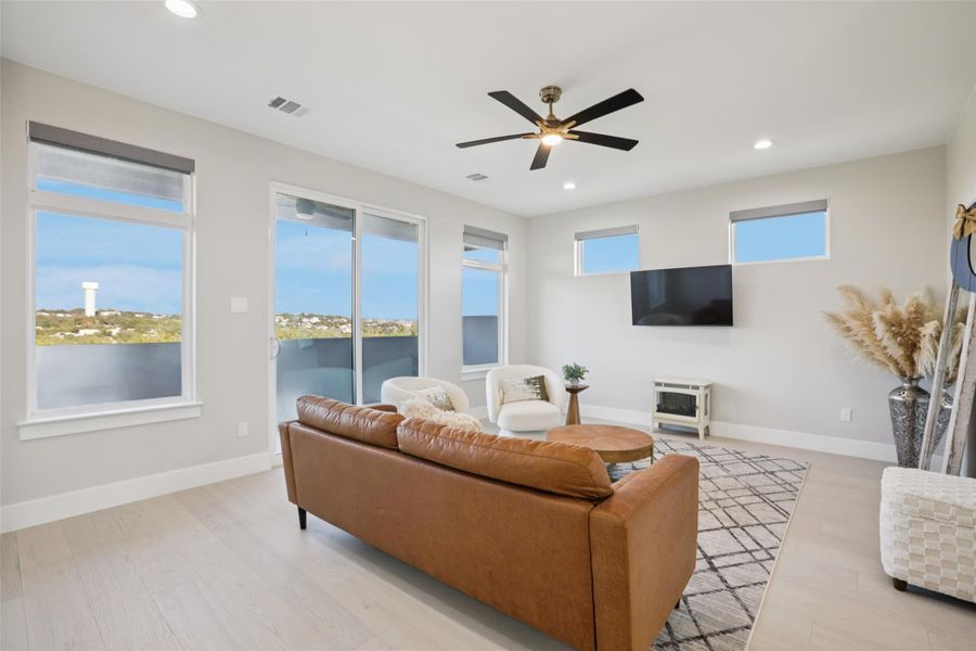 Living room with light wood-style flooring, ceiling fan, and recessed lighting