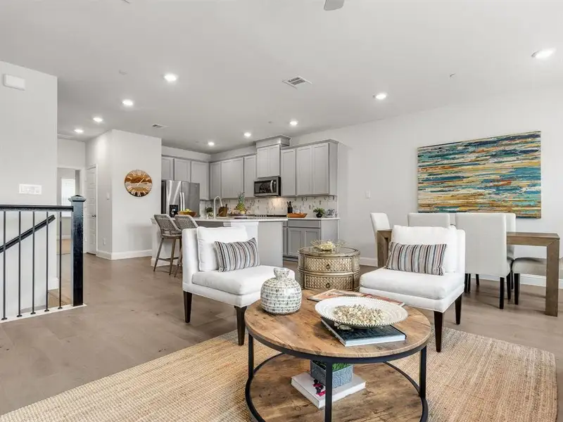 This viewpoint demonstrates the airy open-concept layout, connecting the central living zones directly into the gourmet kitchen.
