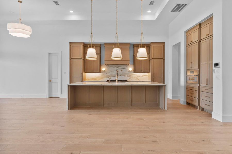The gourmet kitchen features a large island and luxurious finishes as chosen by our award-winning design center. Representative image.