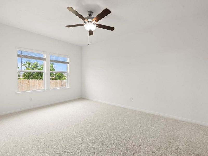Well-lit and tranquil, this bedroom provides a comfortable retreat with a cooling ceiling fan.