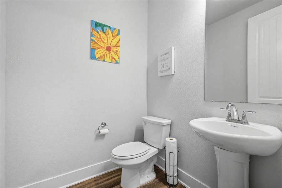 Half Bathroom with dark wood-style finished floors and a textured wall Half Bathroom with dark wood-style finished floors and a textured wall