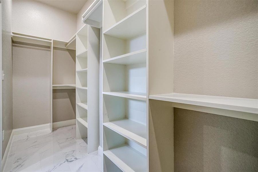 Walk in closet featuring marble finish floor Walk in closet featuring marble finish floor