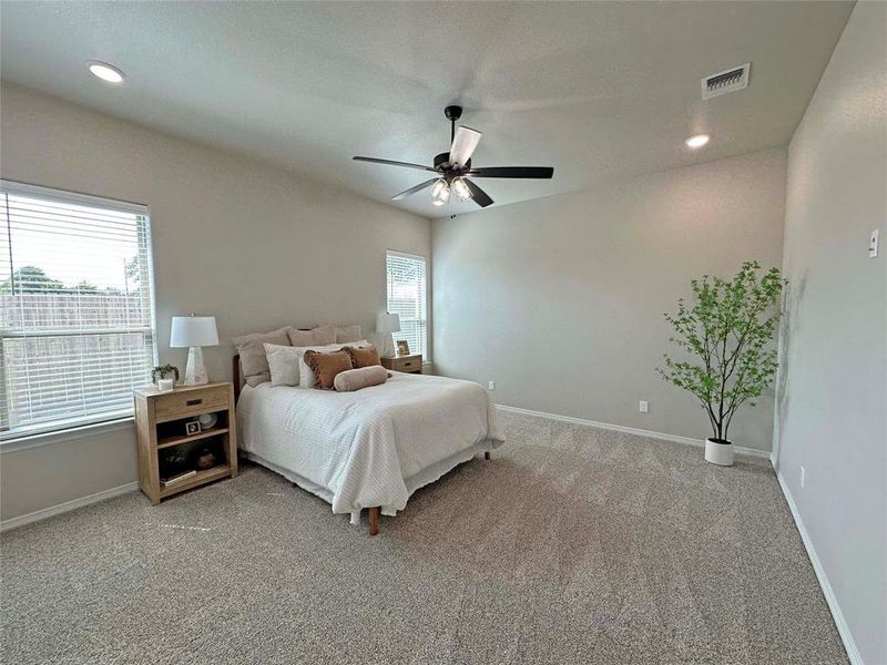 Bedroom with light colored carpet, recessed lighting, and a ceiling fan Bedroom with light colored carpet, recessed lighting, and a ceiling fan