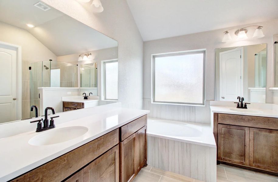 Bathroom with two vanities, lofted ceiling, a stall shower, and a bath Bathroom with two vanities, lofted ceiling, a stall shower, and a bath