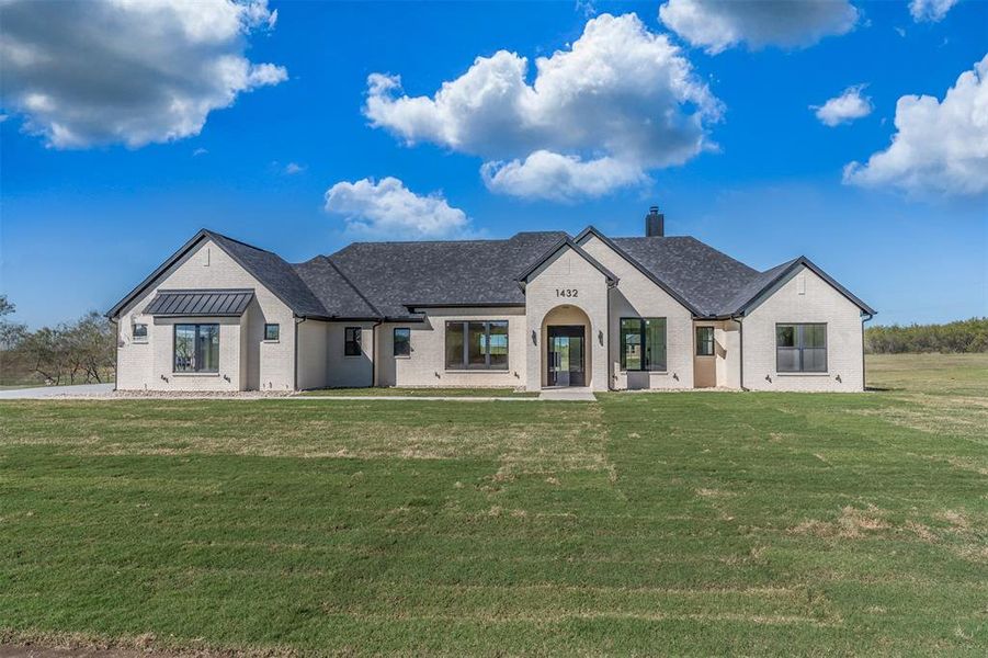 French provincial home featuring a front yard