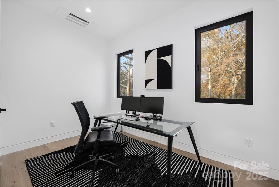 Main-level guest bedroom with ensuite bathroom, currently utilized as a home office.