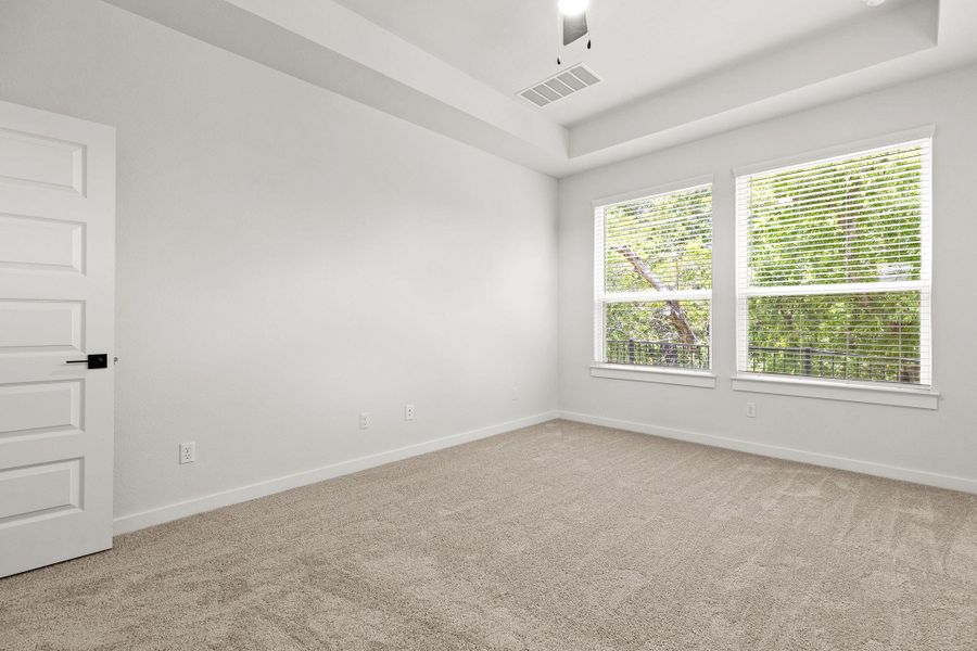 A quiet retreat with a classic tray ceiling and abundant natural light from wide windows. A quiet retreat with a classic tray ceiling and abundant natural light from wide windows.