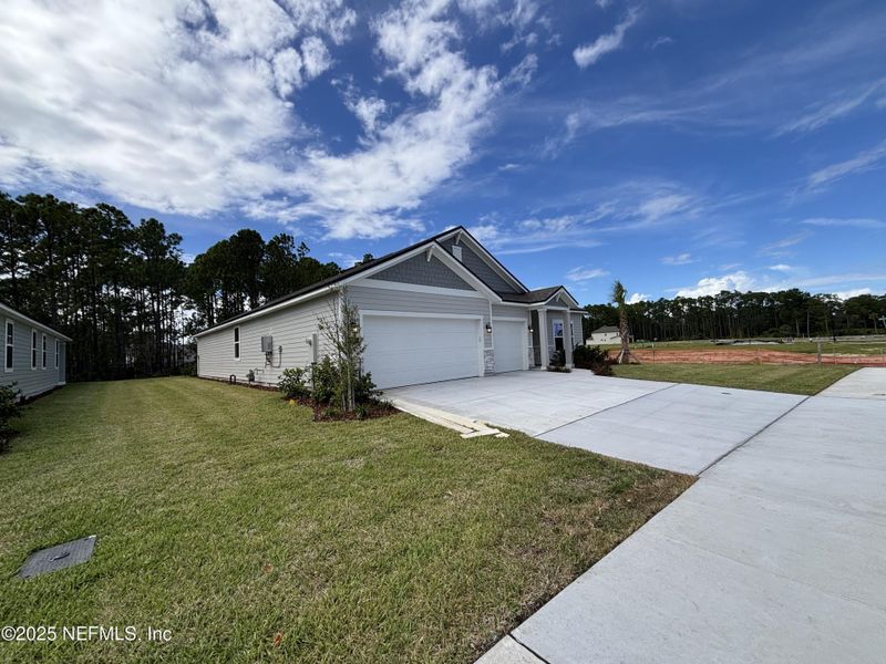 Front exterior of a new home in The Cypress Series at Reserve East, Flagler Beach, FL, highlighting curb appeal (Image 14).