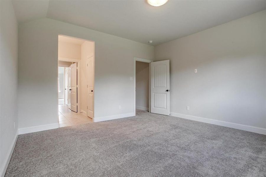 Unfurnished room with lofted ceiling and light colored carpet