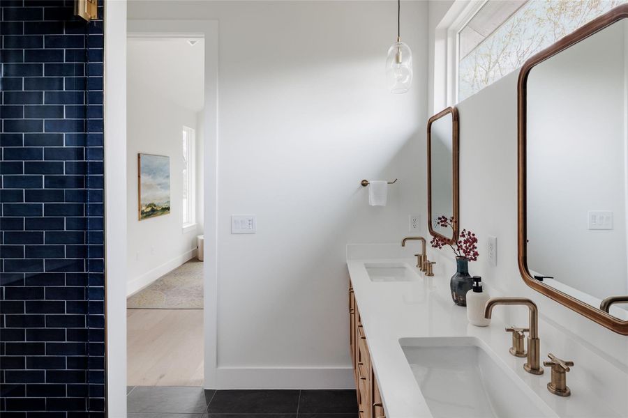 Full bath with double vanity and dark tile patterned floors