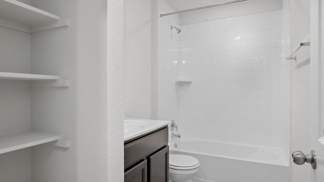 Bathroom with vanity, tub / shower combination, and a textured wall