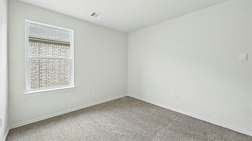 Bright room featuring a double-hung window, light gray carpet, white baseboards, and neutral wall paint Bright room featuring a double-hung window, light gray carpet, white baseboards, and neutral wall paint