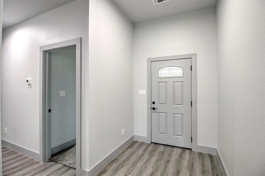 Foyer featuring light wood-type flooring and baseboards Foyer featuring light wood-type flooring and baseboards