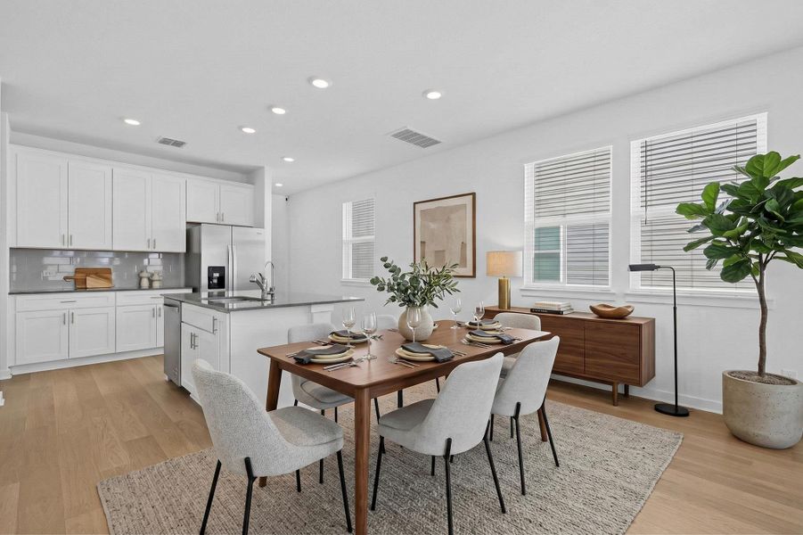 Dining area with light wood-style floors and recessed lighting