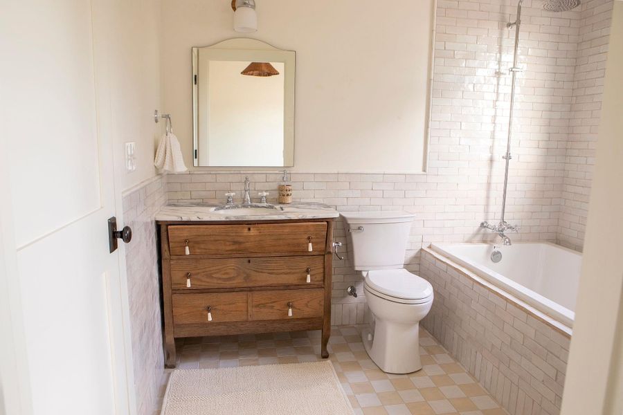 Bathroom featuring tiled shower / bath combo, tile walls, and vanity Bathroom featuring tiled shower / bath combo, tile walls, and vanity