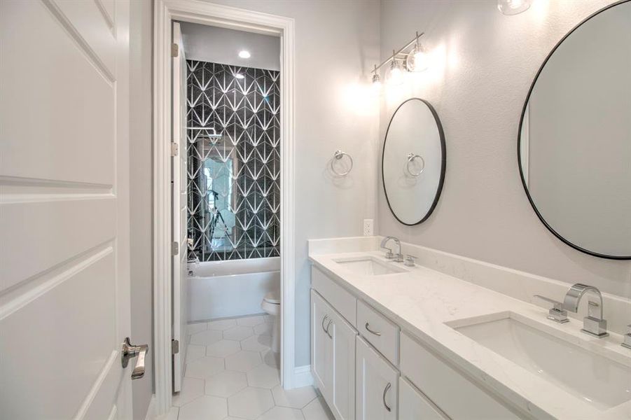 Full bathroom featuring tile patterned floors, tiled shower / bath combo, toilet, and vanity