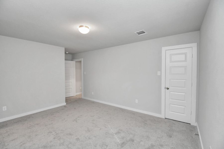 Secondary bedroom features plush carpeting, large windows that let in plenty of natural light, bright paint, and spacious closets.
