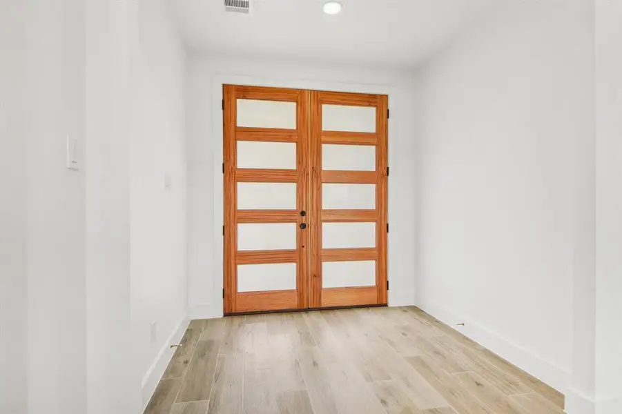 Doorway with wood finished floors and recessed lighting Doorway with wood finished floors and recessed lighting
