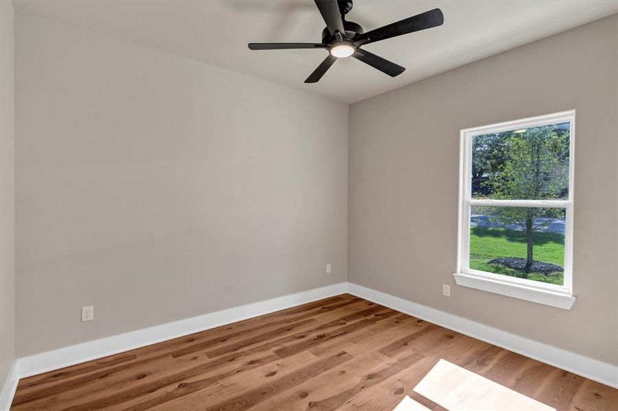 Empty room featuring light wood-style flooring and ceiling fan Empty room featuring light wood-style flooring and ceiling fan