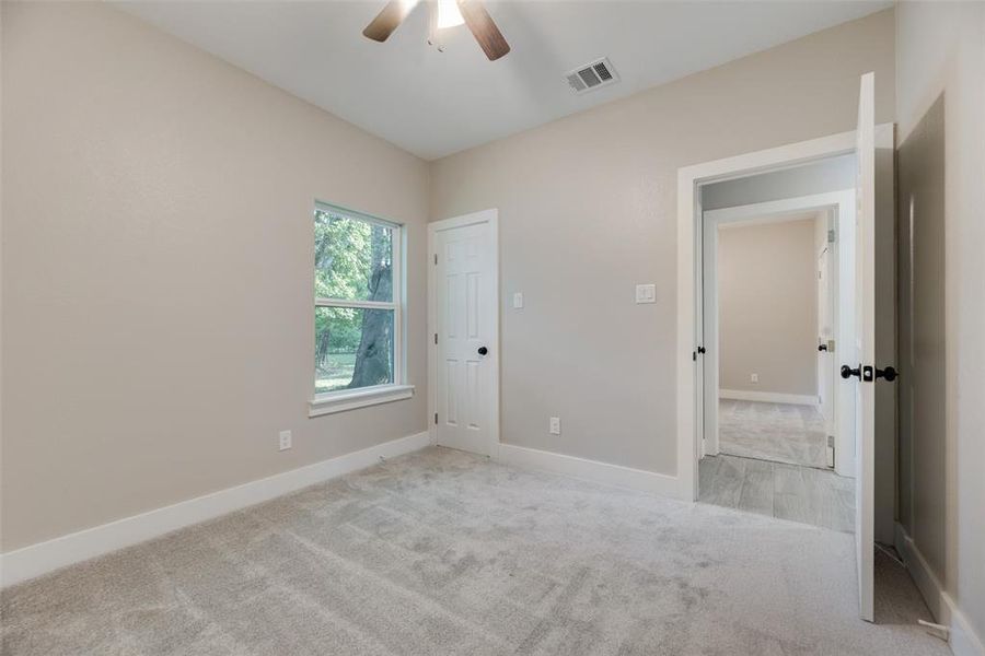 Unfurnished bedroom #1with light carpet and ceiling fan