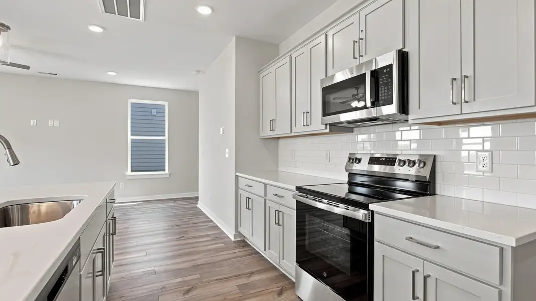 Countertop space combined with oven and microwave across from island with sink Countertop space combined with oven and microwave across from island with sink