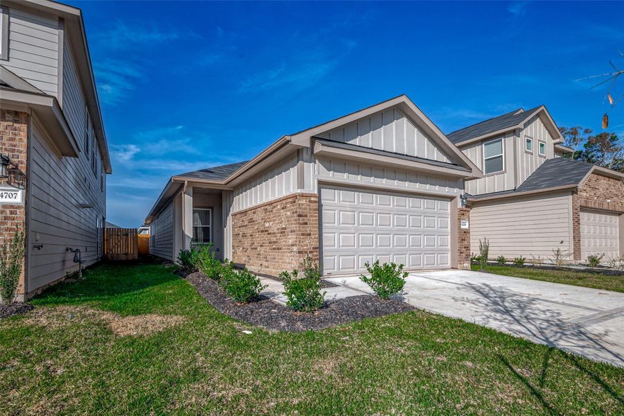 Front exterior of a new home in Woodland Lakes, Huffman, TX, highlighting curb appeal (Image 20).