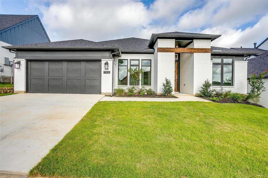 View of front of house with a front yard and a garage