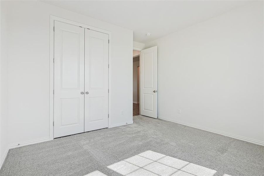 Unfurnished bedroom featuring a closet and light carpet