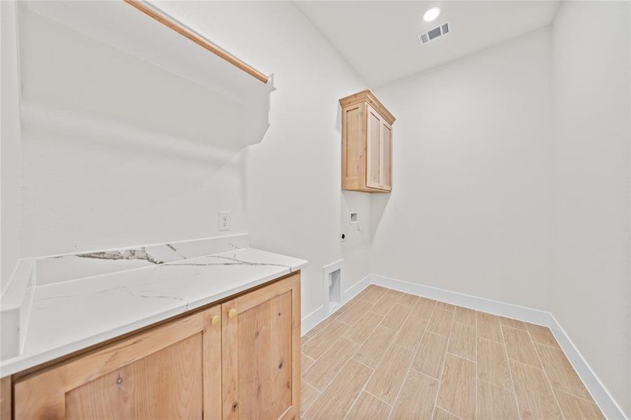 Laundry area with cabinet space, hookup for an electric dryer, washer hookup, recessed lighting, and wood tiled floors Laundry area with cabinet space, hookup for an electric dryer, washer hookup, recessed lighting, and wood tiled floors