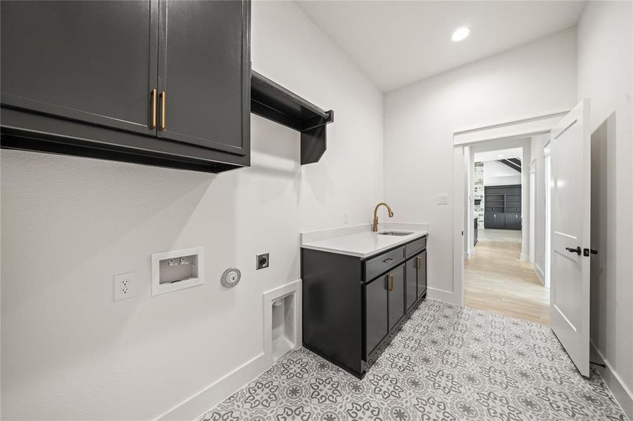 Laundry area with cabinet space, hookup for an electric dryer, hookup for a gas dryer, hookup for a washing machine, and recessed lighting