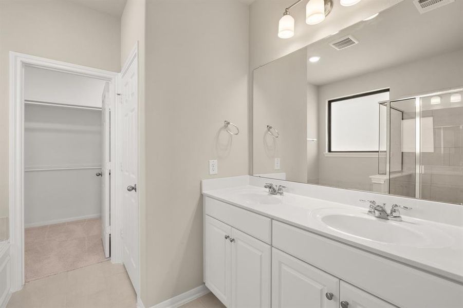 The en-suite bathroom offers a spa-like atmosphere with its elegant design, high end finishes, and tasteful lighting, creating a retreat within your own home.