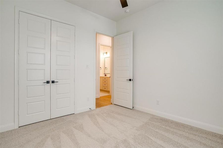 Unfurnished bedroom with light carpet, a closet, and ceiling fan