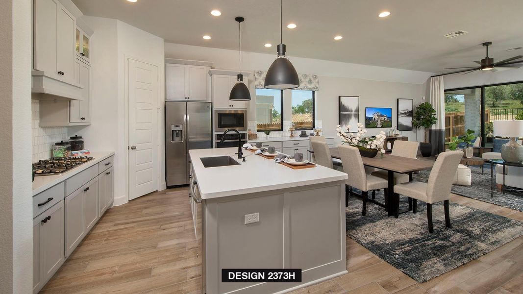 Kitchen with recessed lighting, stainless steel appliances, open floor plan, hanging light fixtures, and light wood-style flooring Kitchen with recessed lighting, stainless steel appliances, open floor plan, hanging light fixtures, and light wood-style flooring
