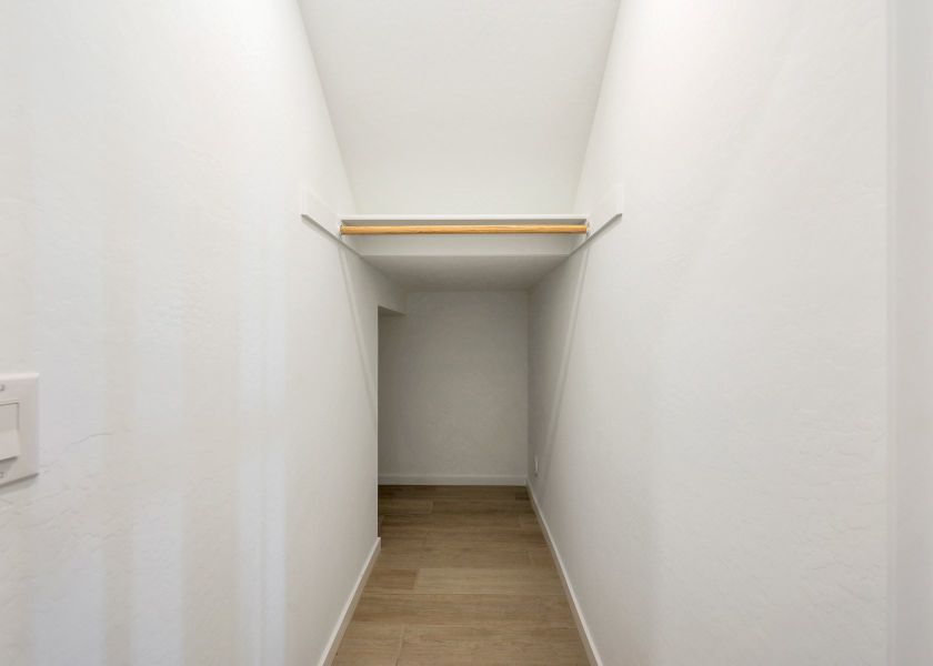 A white room with a wooden shelf.