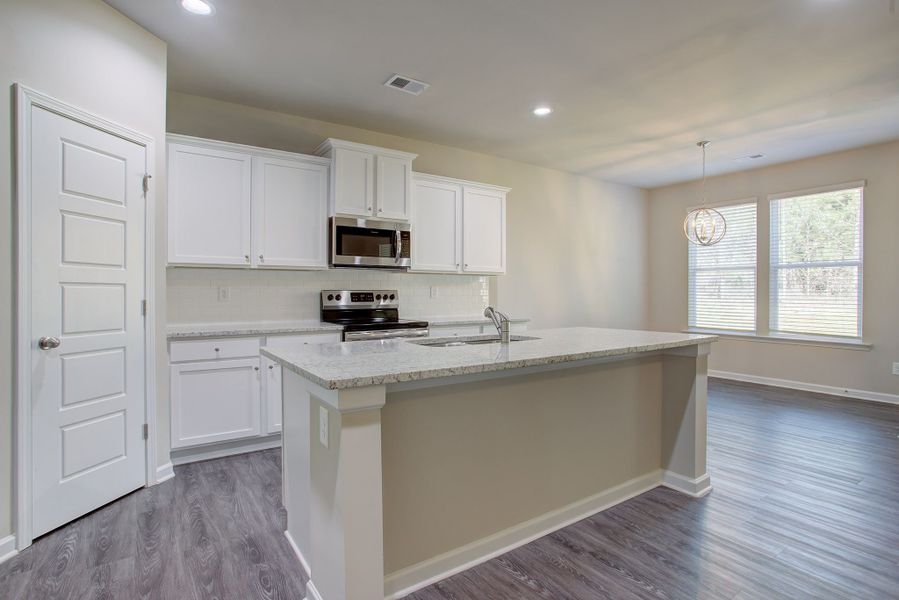 The large kitchen opens to the breakfast area and family room