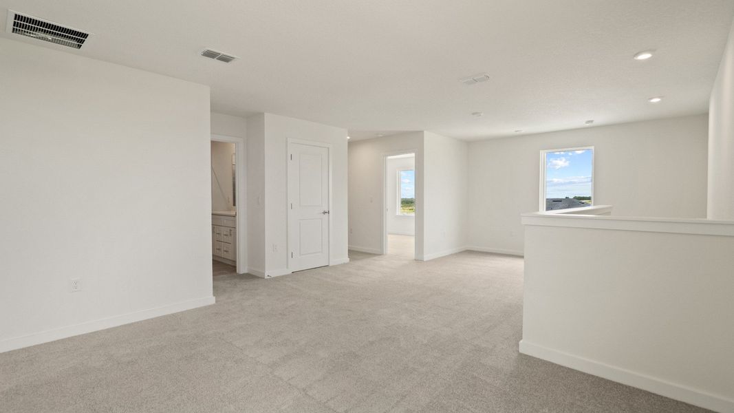 Bright and open upstairs landing connects living spaces, offering flexibility for a reading nook, desk, or lounge area
