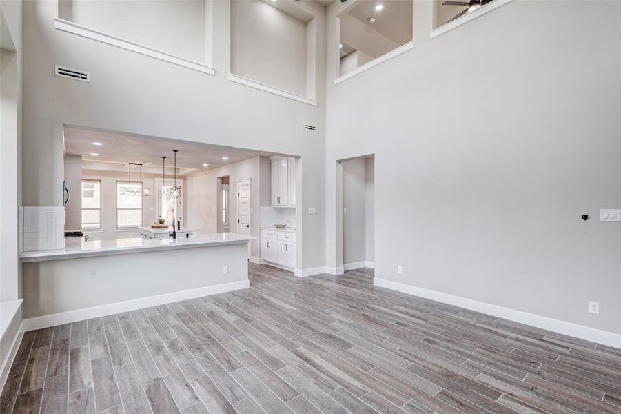 living room with light wood-type tile flooring and a towering ceiling