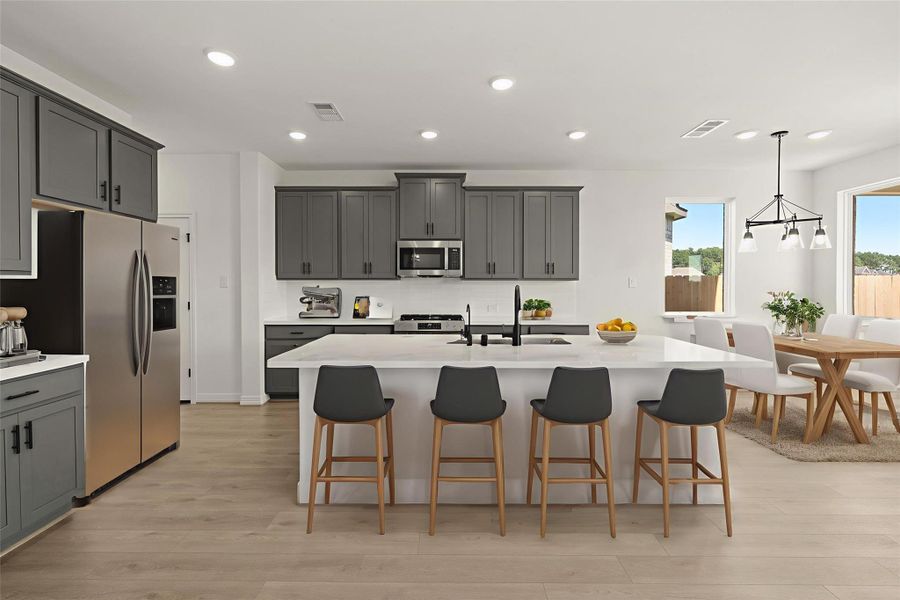 This light and bright kitchen features a large quartz island, white cabinets, a large sink overlooking your family room, recessed lighting, and beautiful backsplash. This light and bright kitchen features a large quartz island, white cabinets, a large sink overlooking your family room, recessed lighting, and beautiful backsplash.