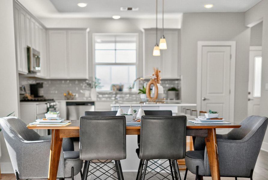 Kitchen with decorative light fixtures, decorative backsplash, white cabinets, stainless steel appliances, and recessed lighting
