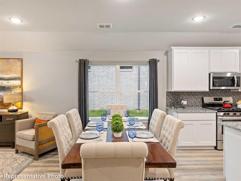 Open-concept living space featuring wood-finish flooring, recessed lighting, and a window with exterior brick wall view