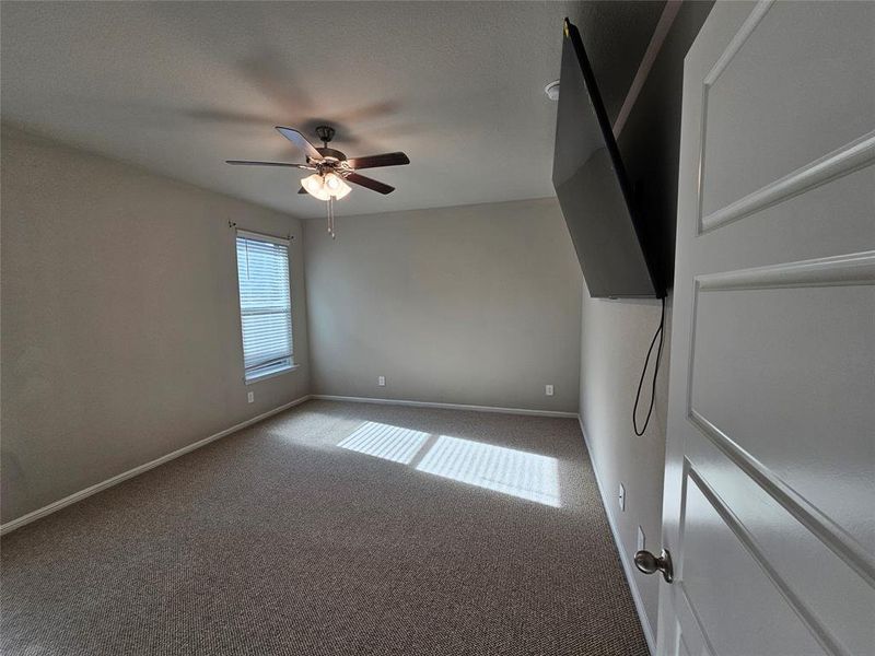 Primary bedroom featuring, moldings, carpet and a ceiling fan.