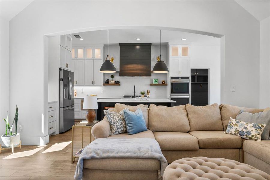 Living area featuring recessed lighting, lofted ceiling, and light wood-type flooring Living area featuring recessed lighting, lofted ceiling, and light wood-type flooring